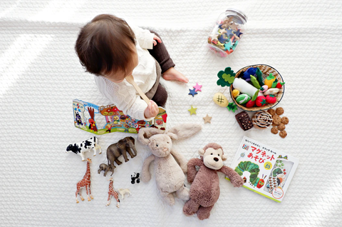 A baby playing with a bunch of toys.