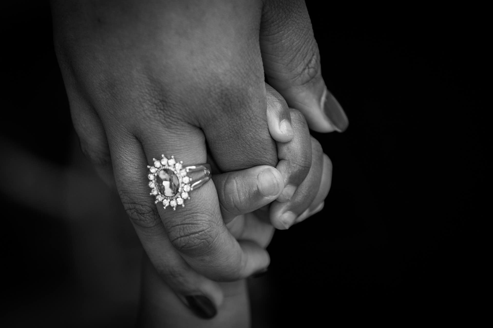 Mother’s hand with a ring holding a child’s