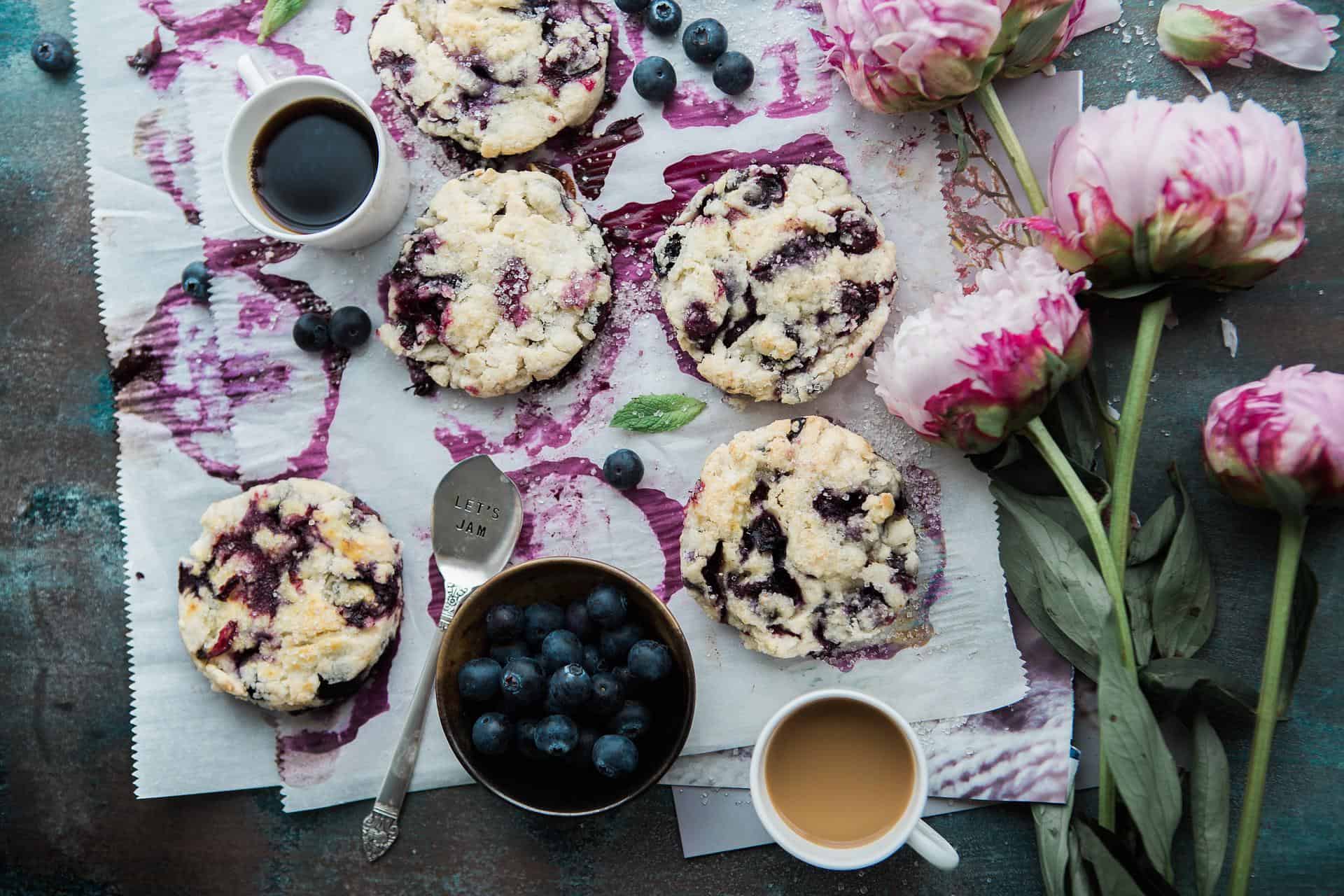 Blueberry cookies with coffee and bowl of blueberries.