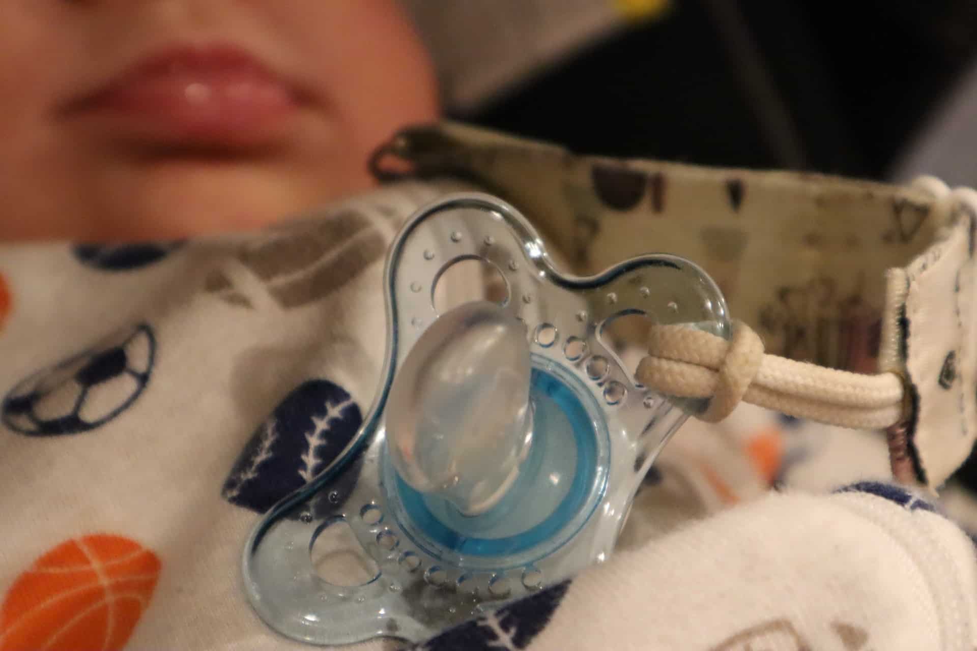 A baby with a pacifier on their chest