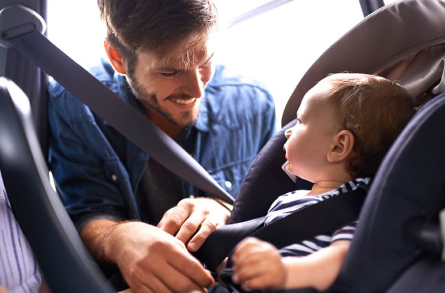 Dad putting baby in carseat