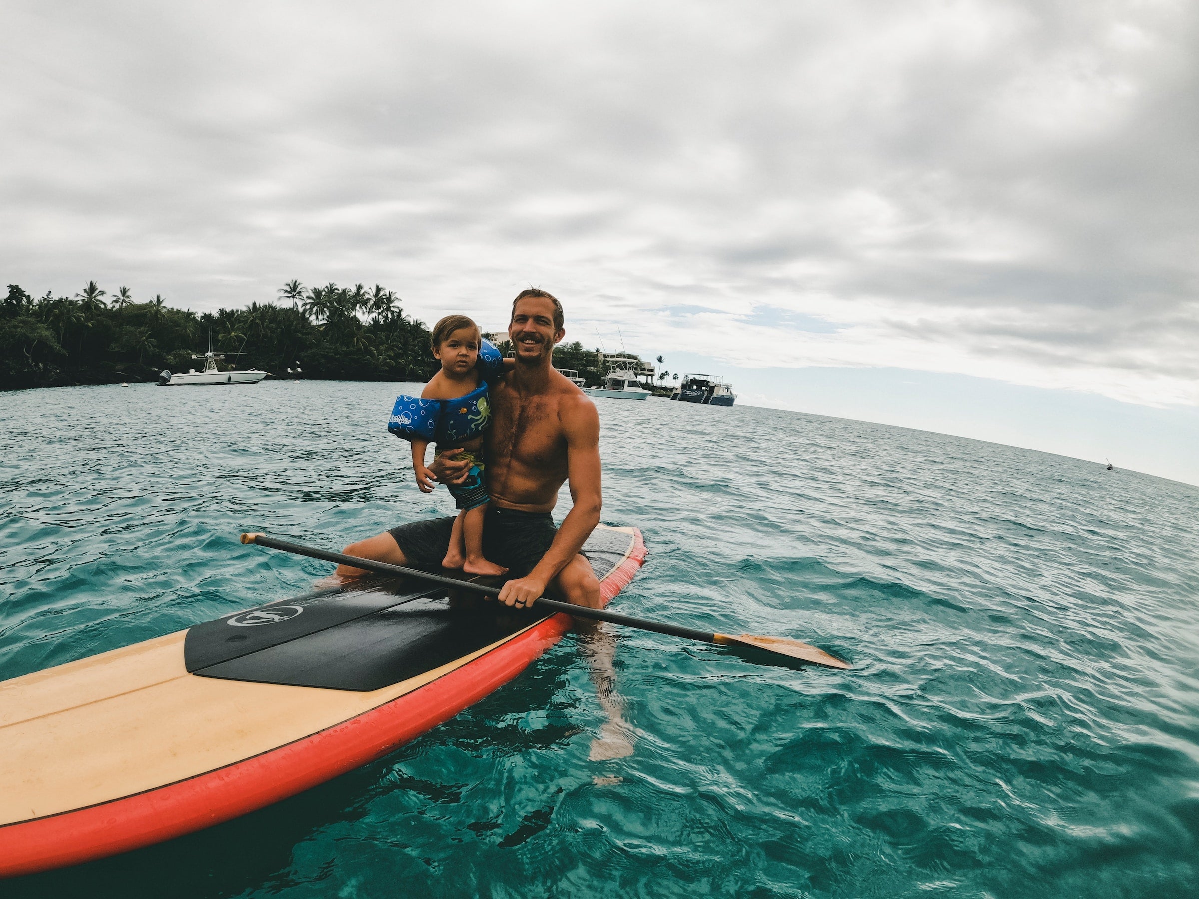 father with baby surfing in hawaii