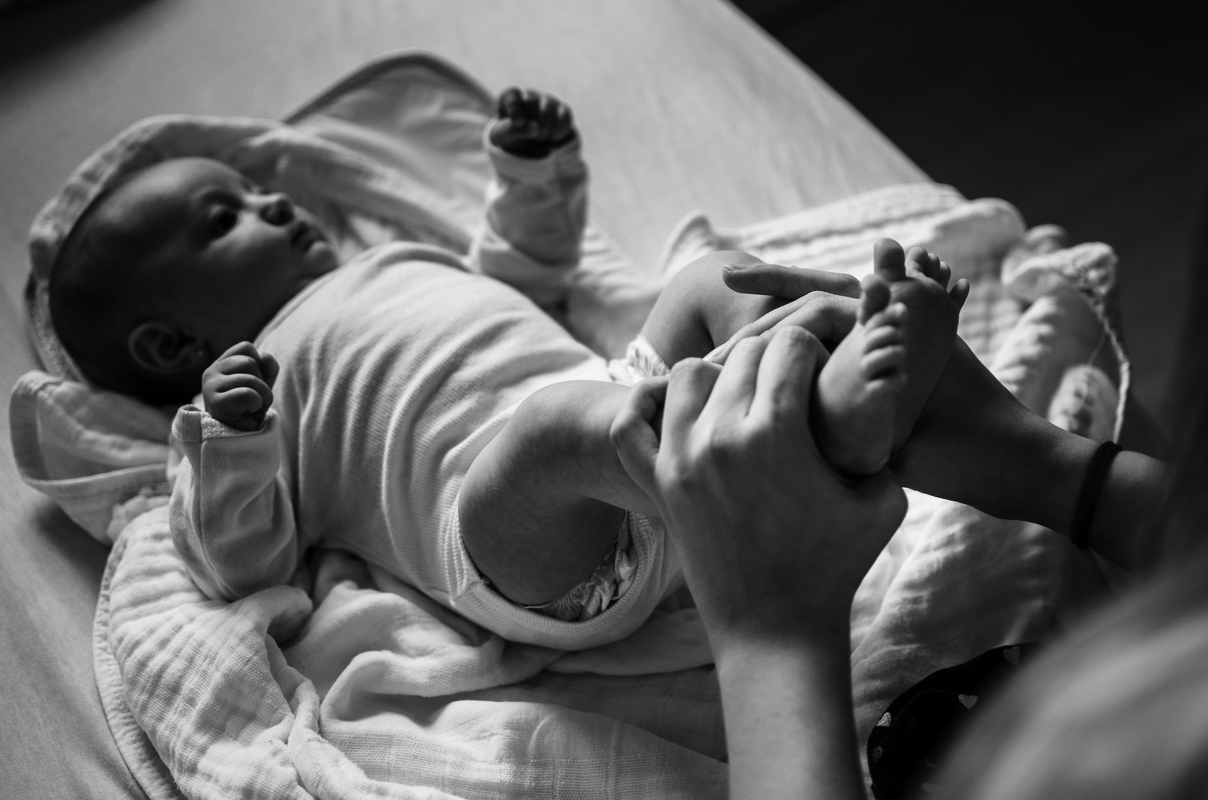 a parent moving a baby’s legs around