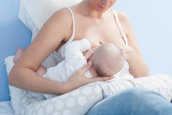 a mother using a nursing pillow