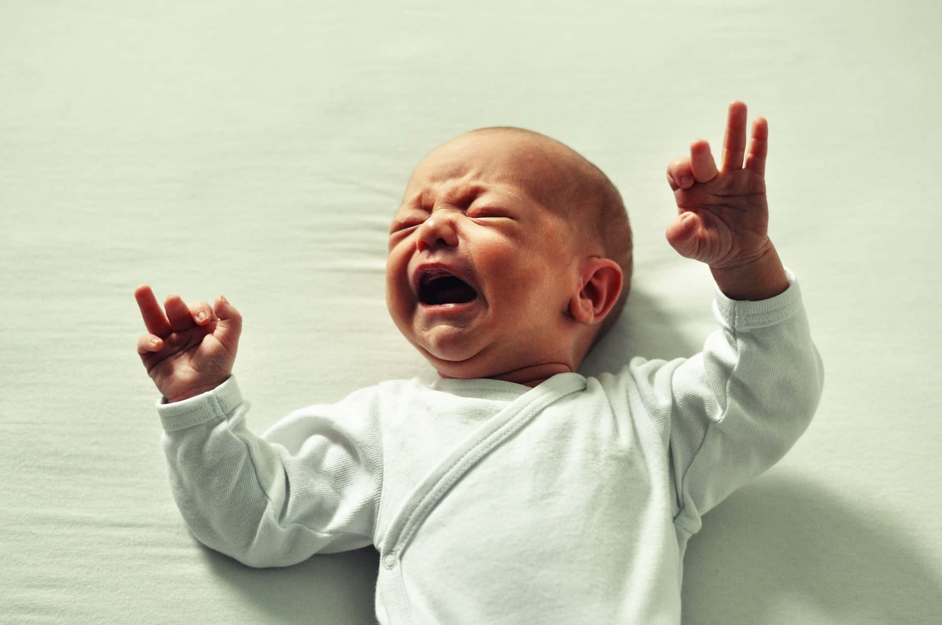 infant laying down and crying