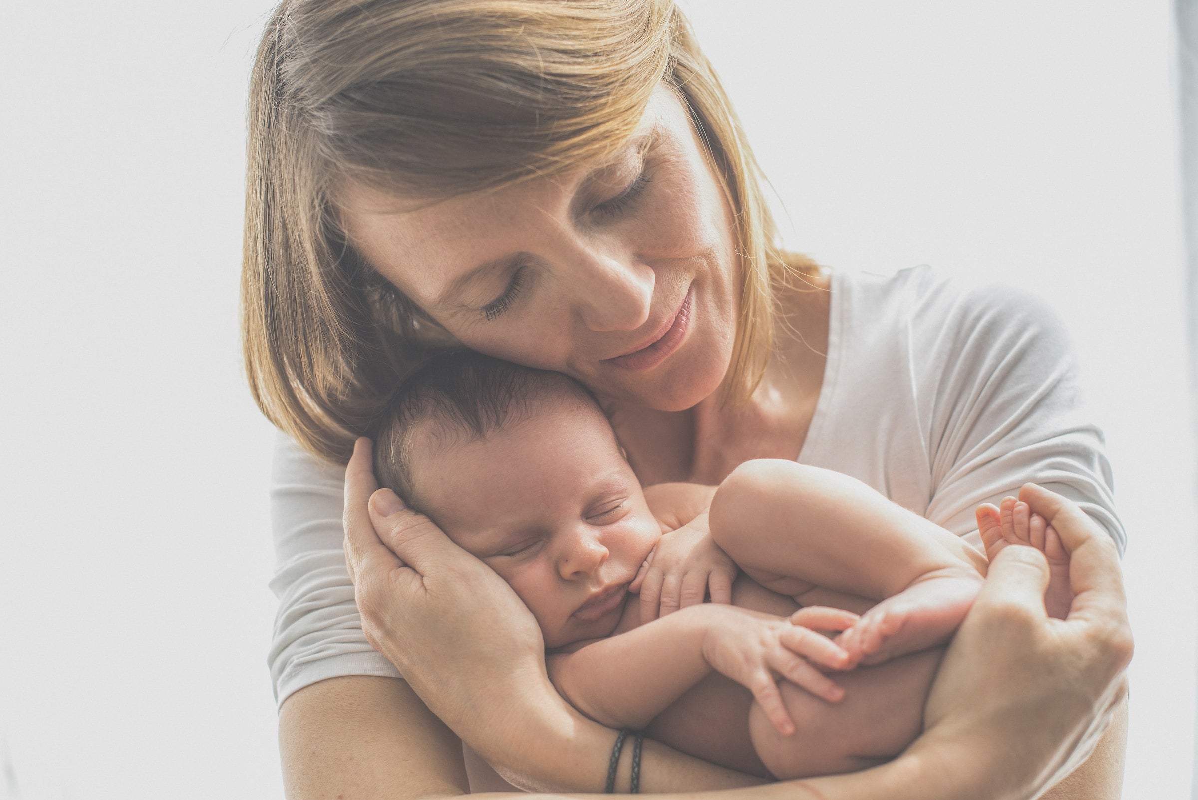 mother embracing newborn baby