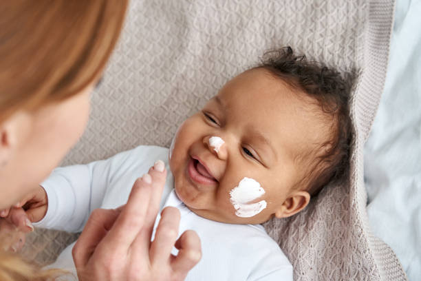 Putting lotion on baby’s face