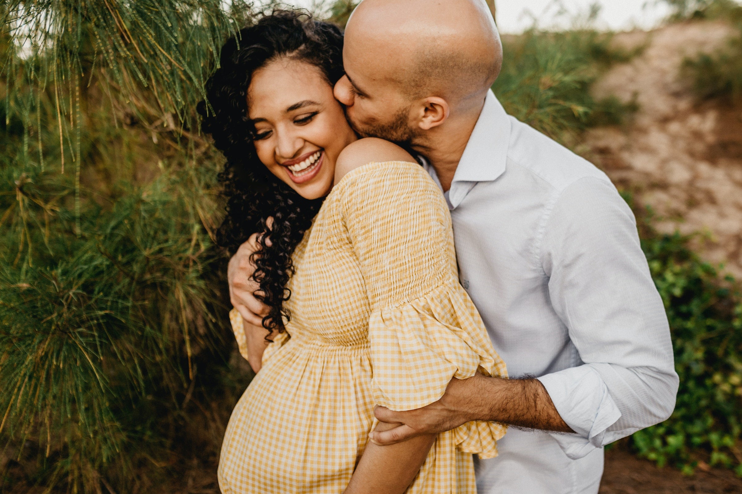 husband kissing pregnant wife