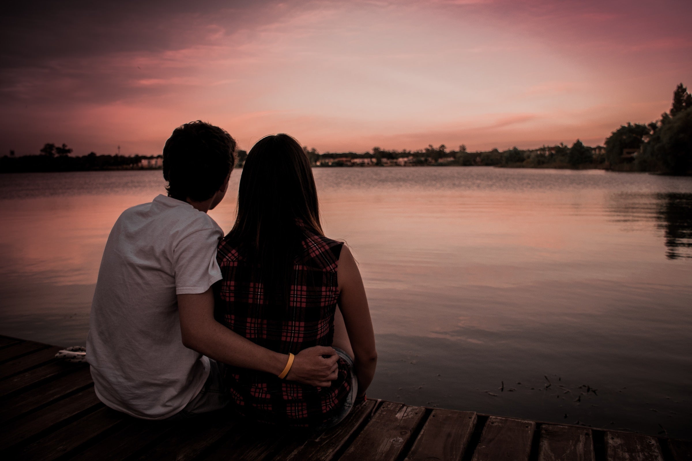 couple holding each other while watching the sunset