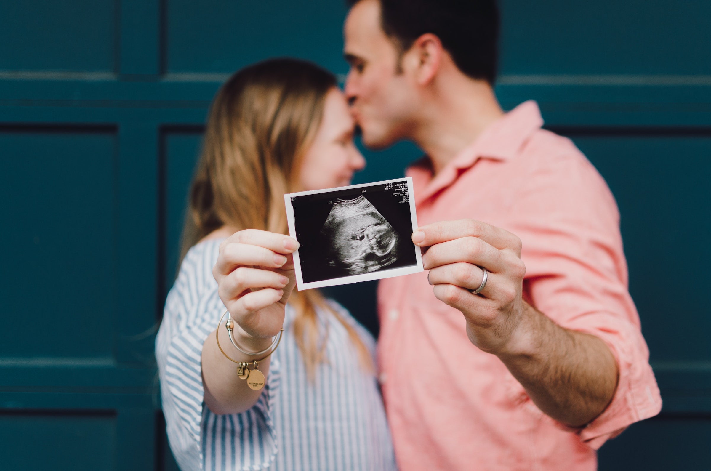 couple holding up ultrasound photo