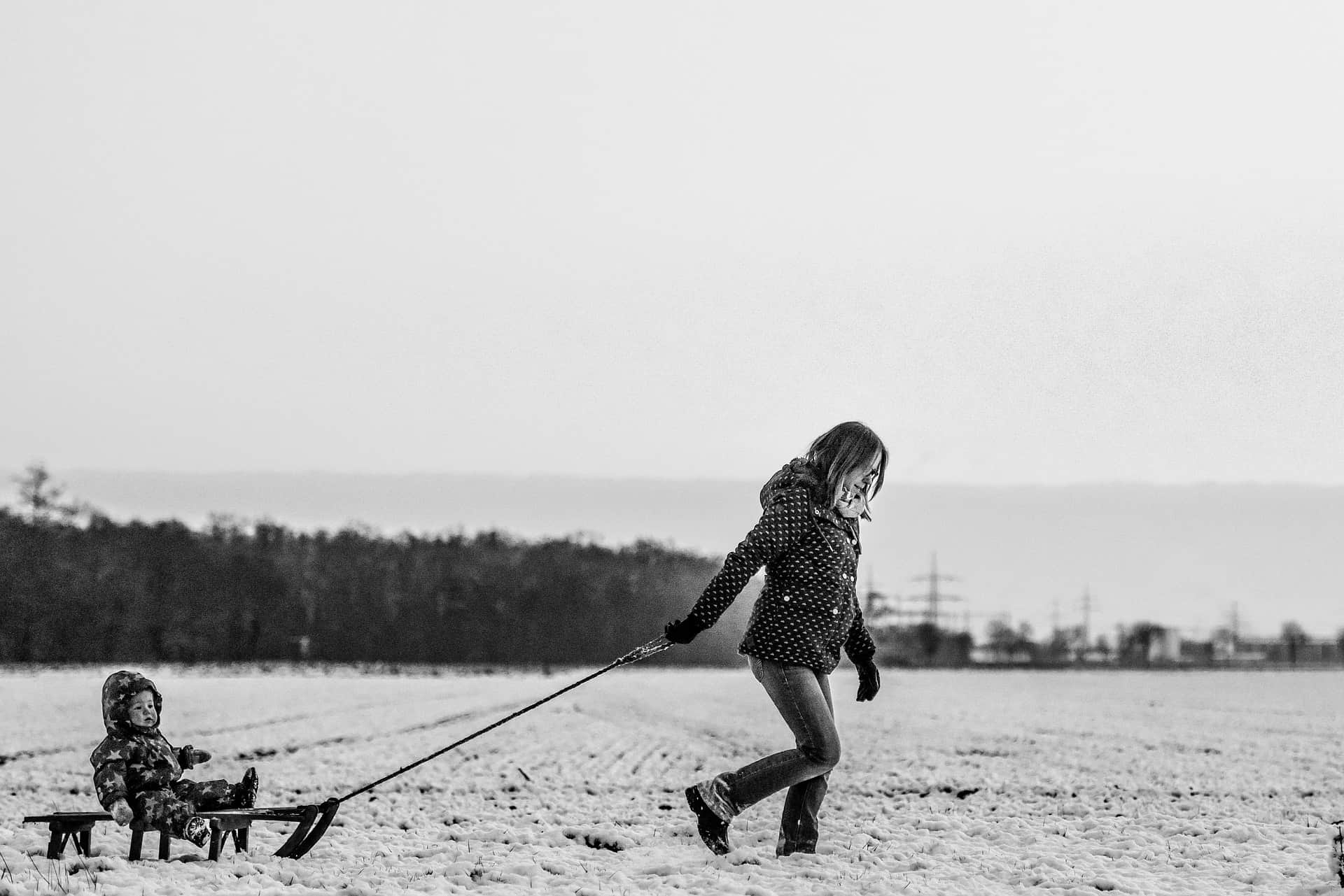Mother pulling child in a sled