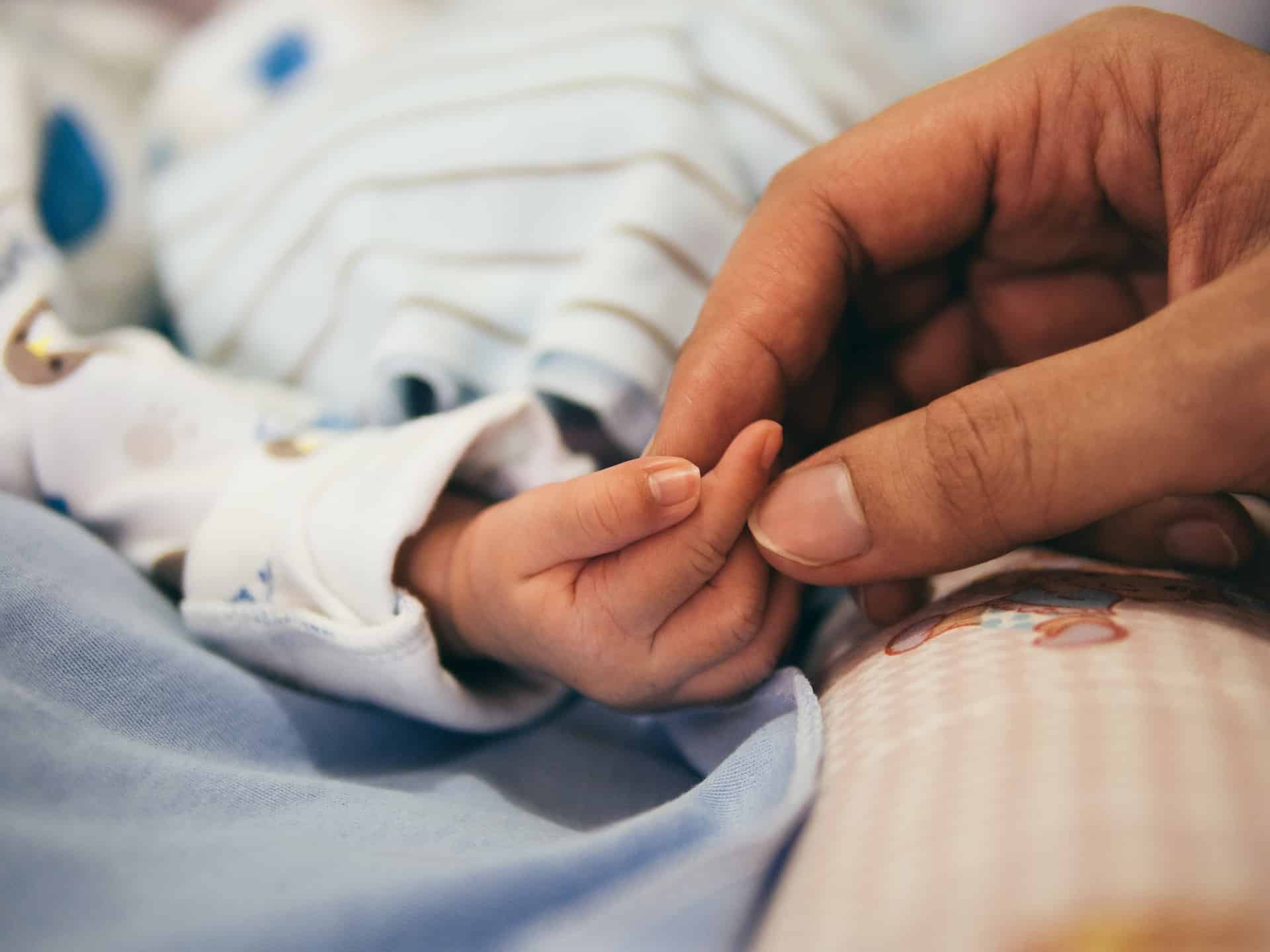 Mother holding baby's hand