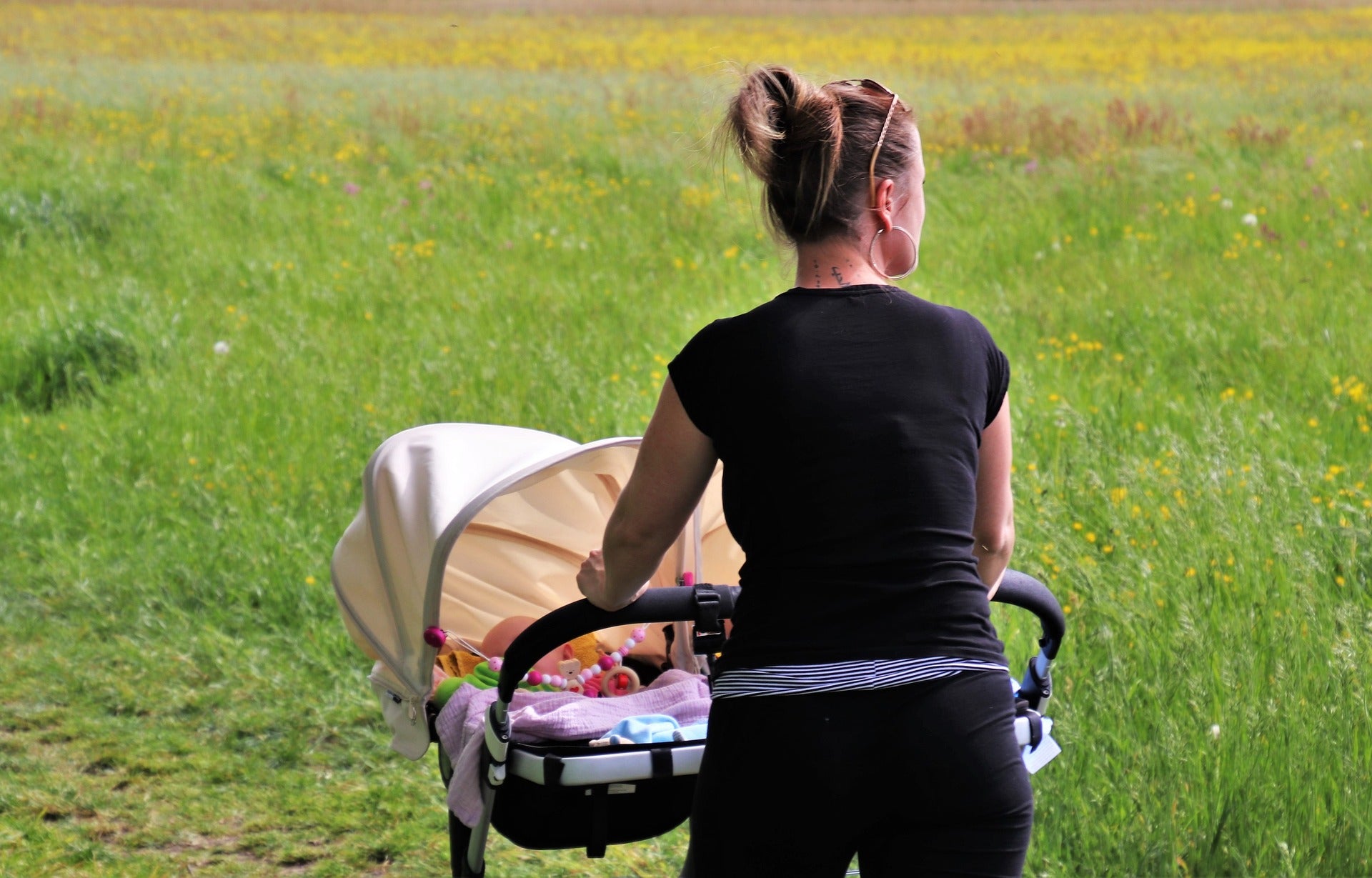 Women with a double stroller in a field 