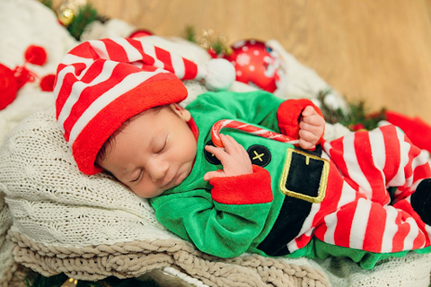 Baby dressed as Santa’s Helper while asleep.