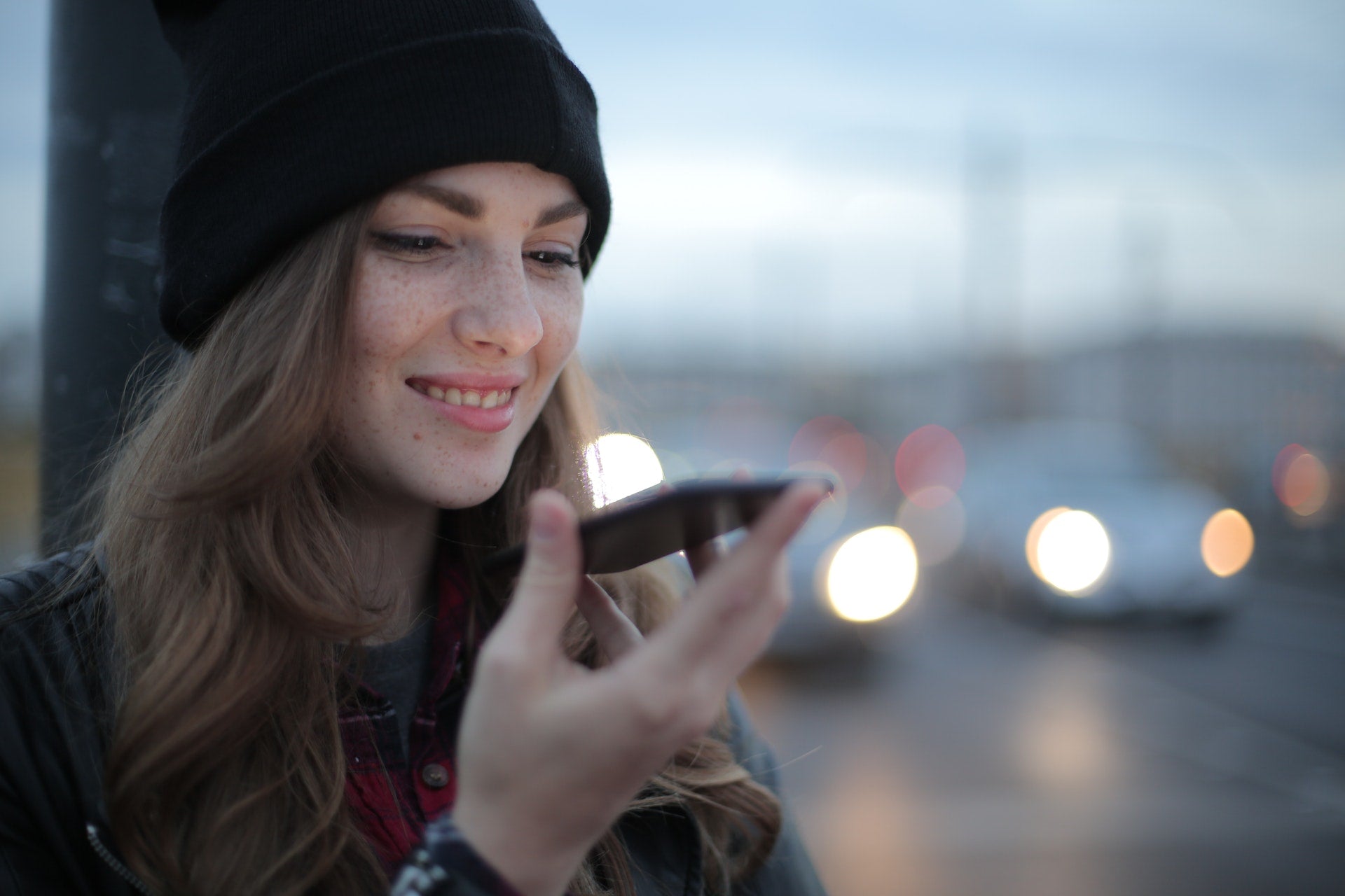 smiling pregnant woman looking at her phone