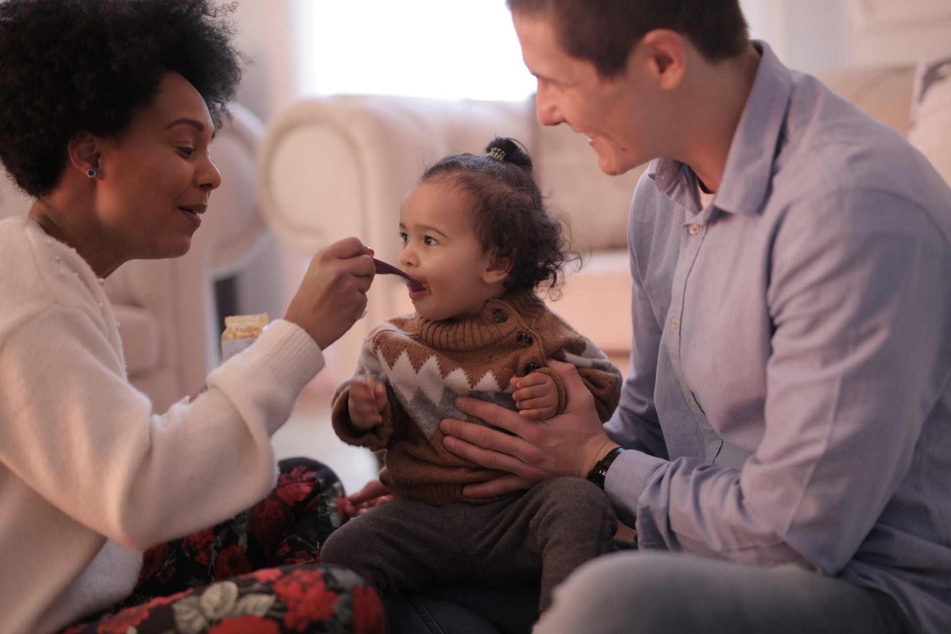 parents feeding a baby