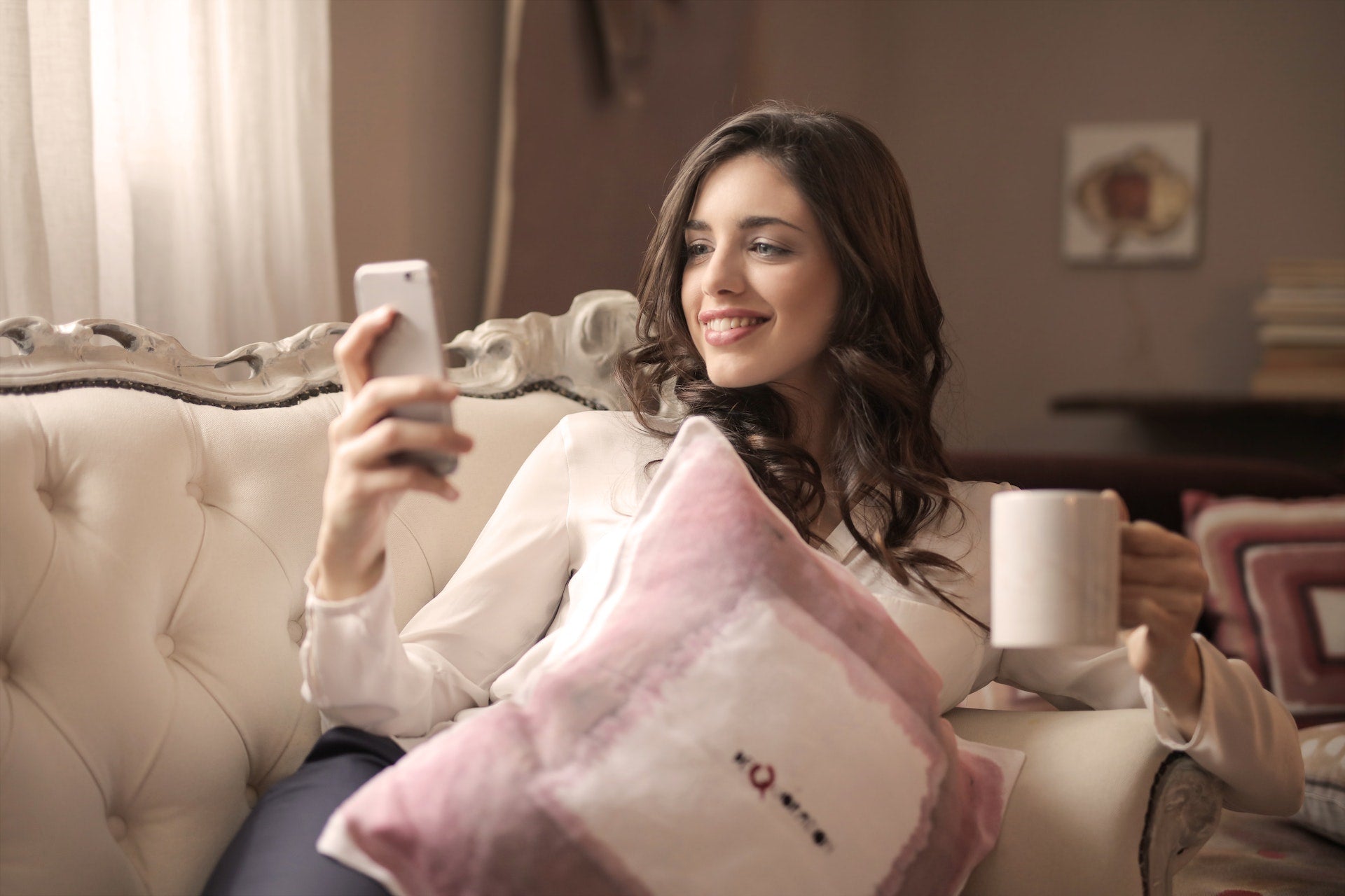 woman holding a cup and phone