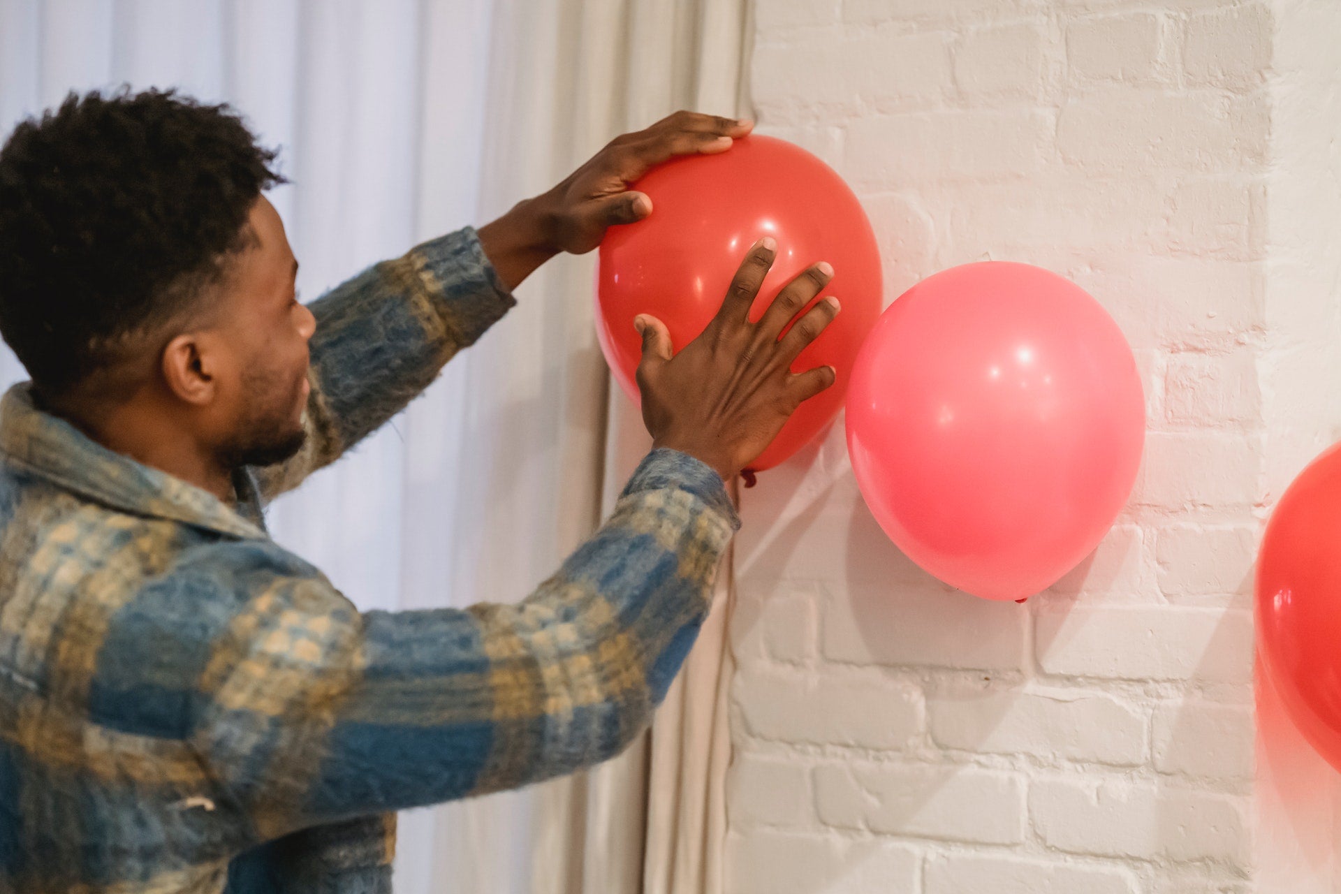 man putting up valentine’s day balloons