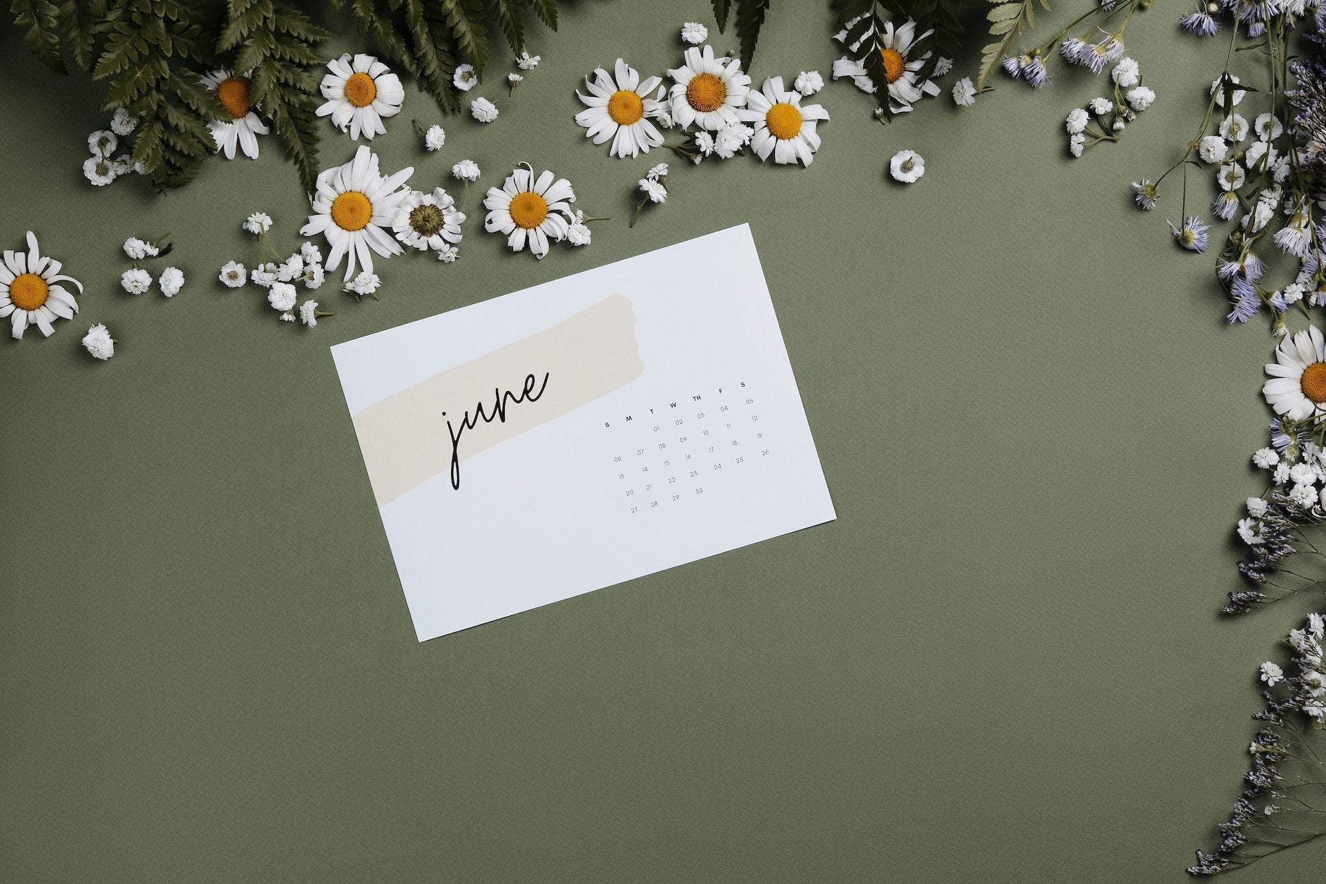 a June calendar page on a wall with flowers