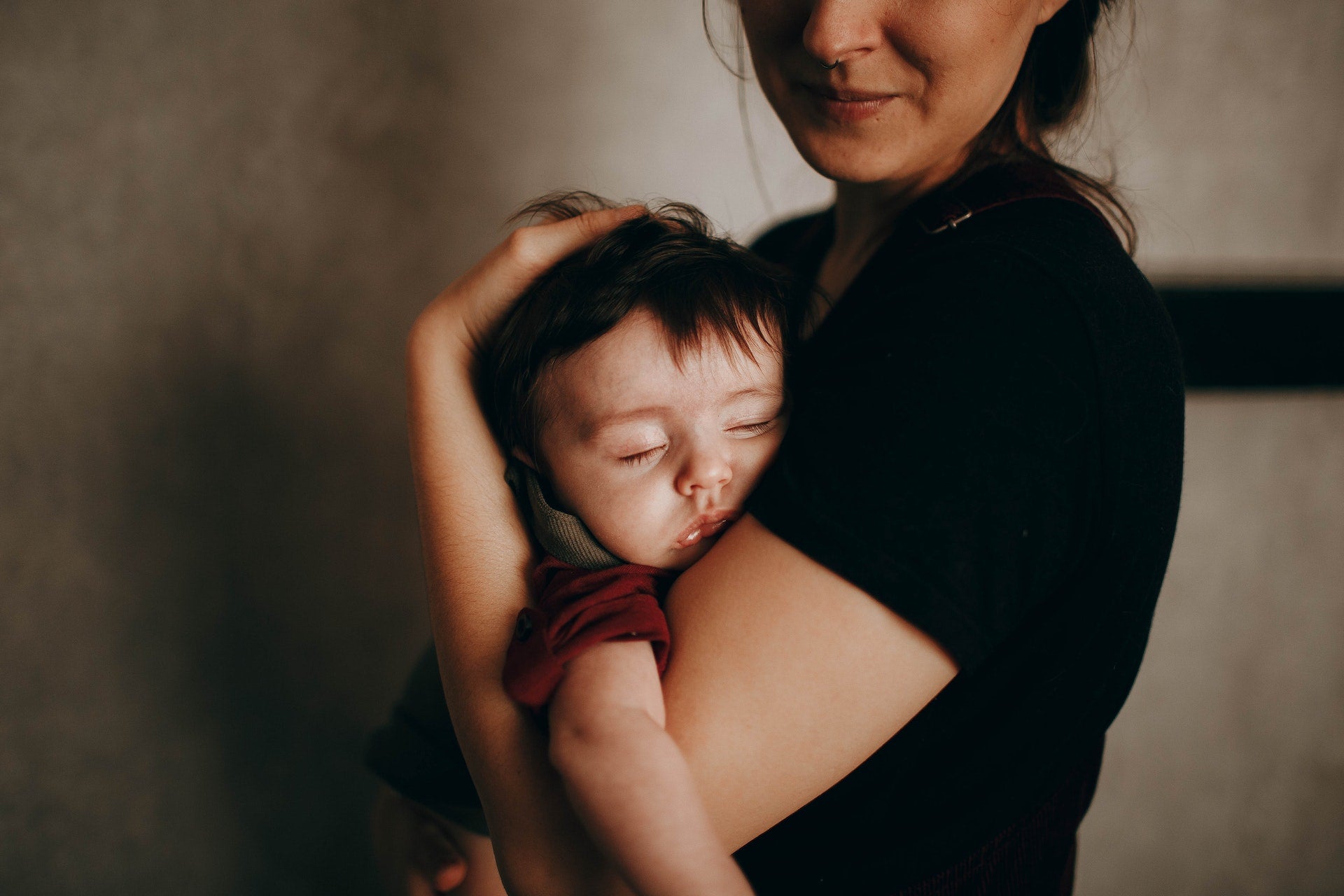 toddler sleeping in mother’s arms