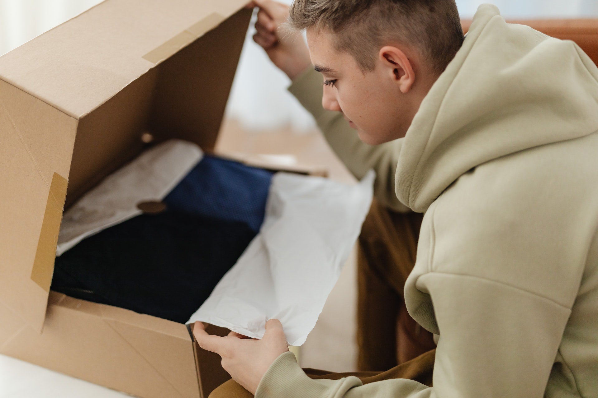 a woman opening a maternity clothing subscription box