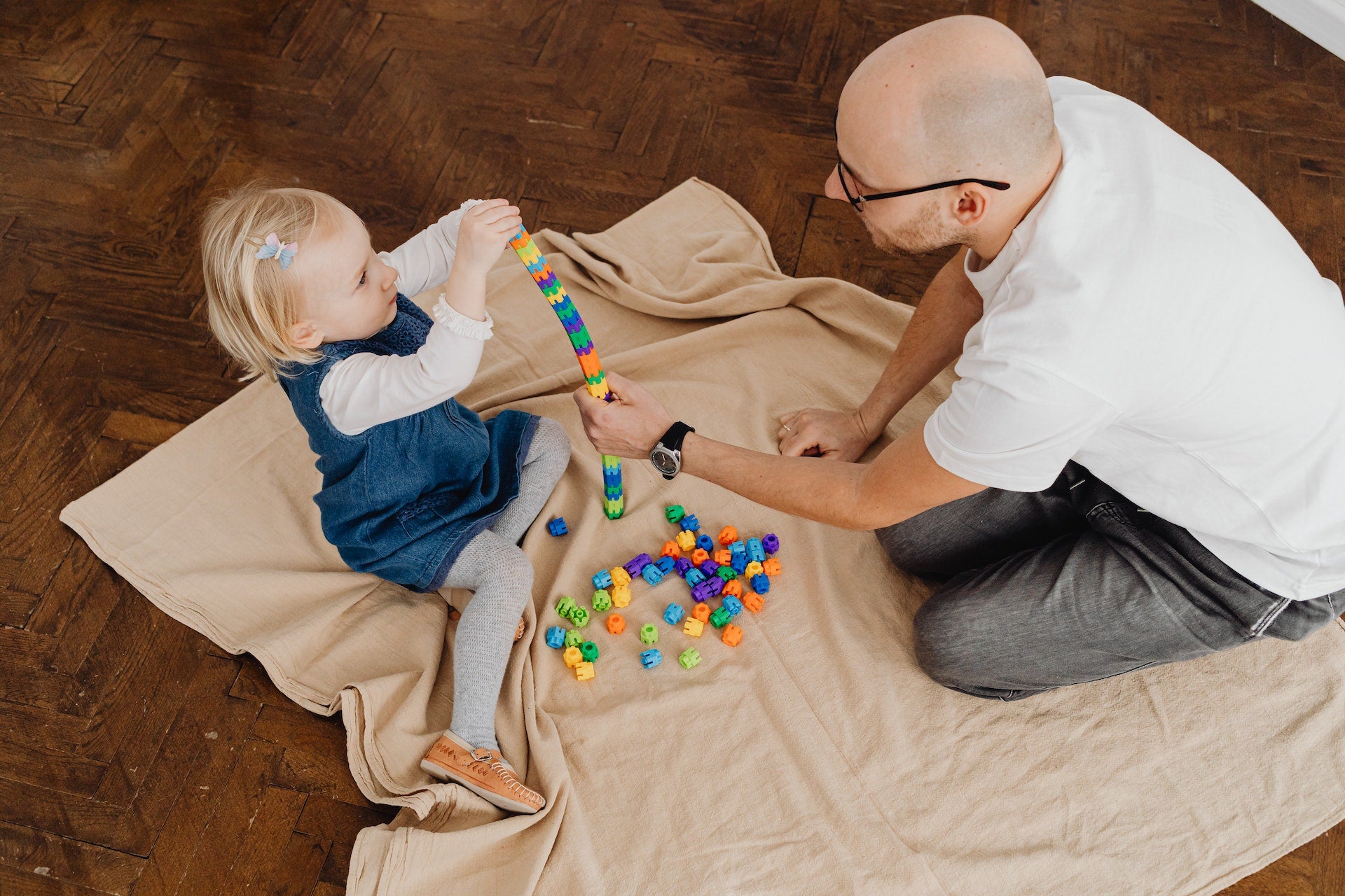 a toddler and her father playing with a stacking toy