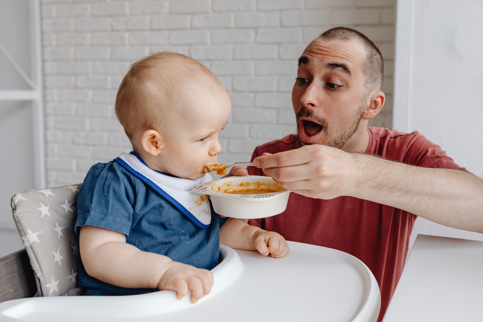 a father feeding his baby with a spoon