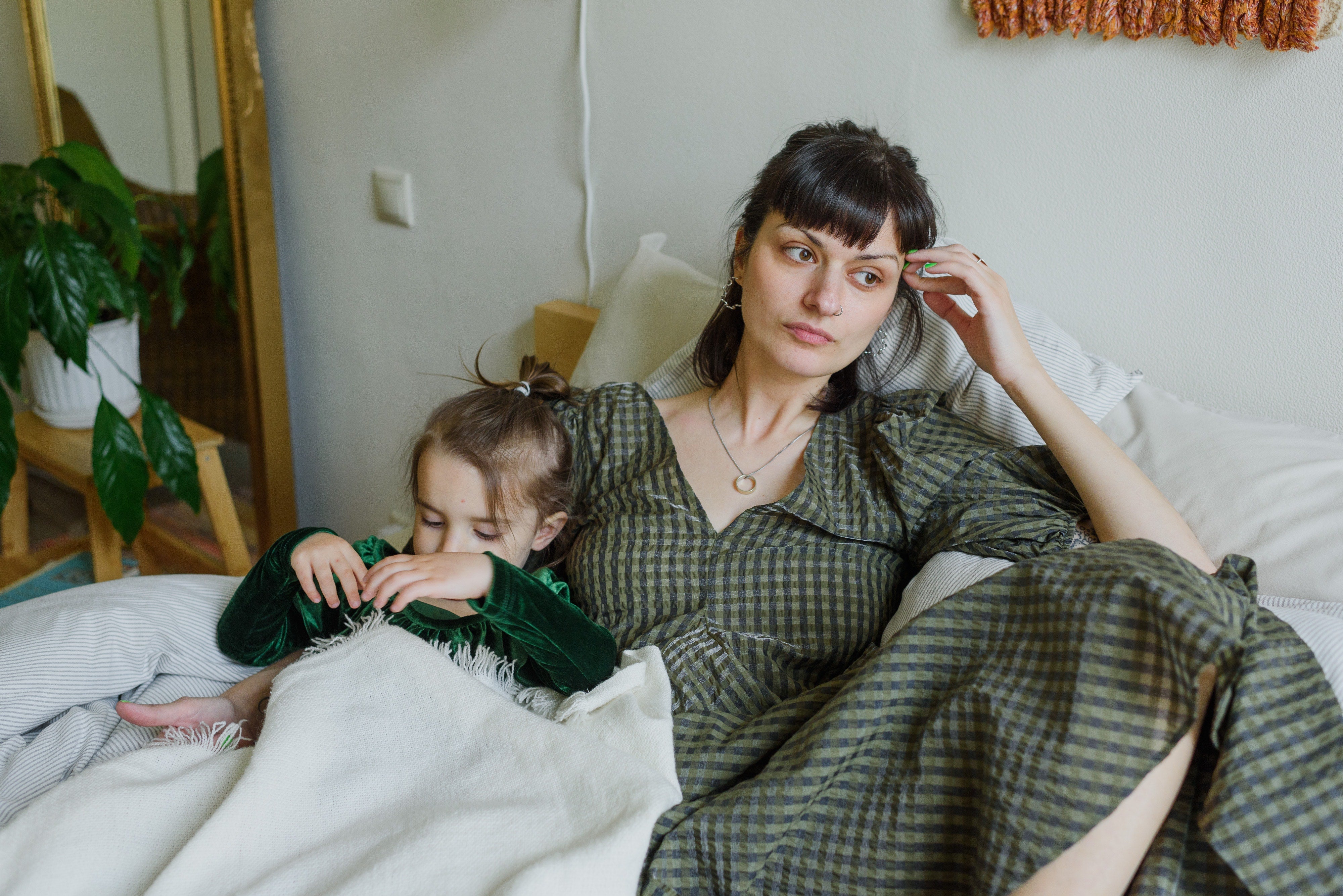 tired mother in a bed with her child