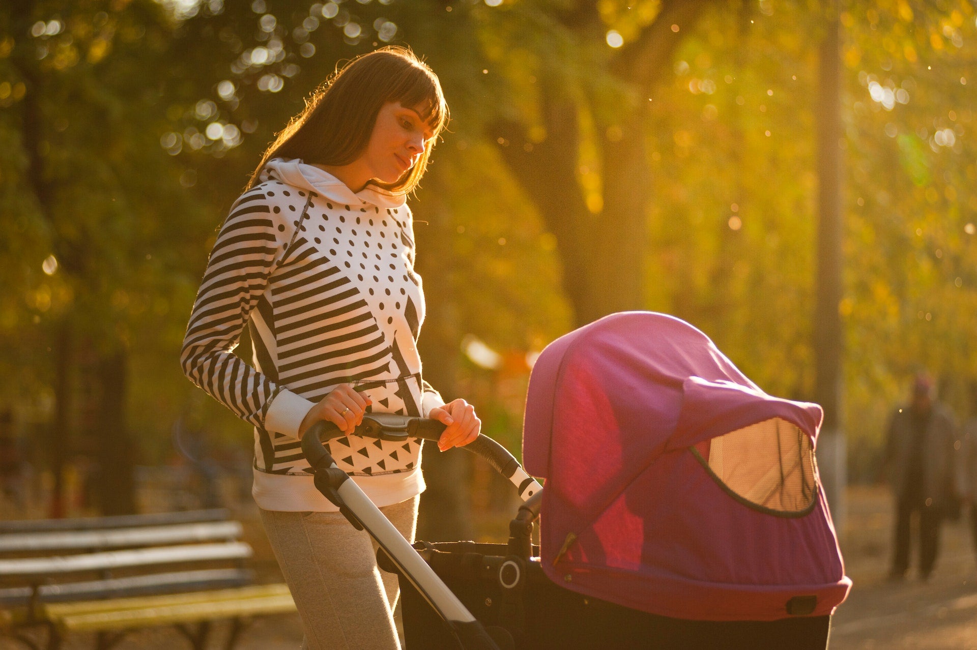 mother walking her baby in a stroller outside