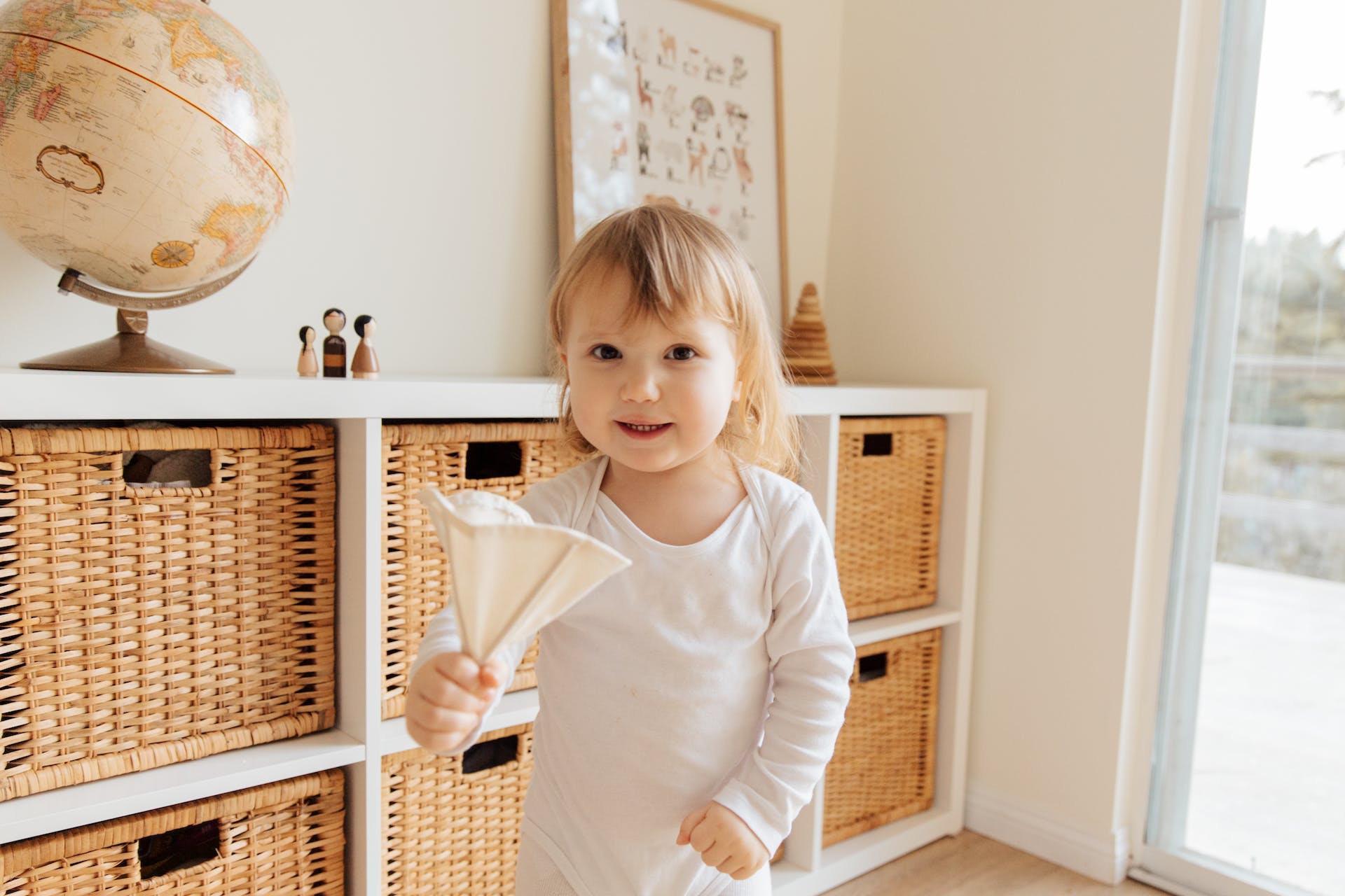 Toddler stands in front of woven storage baskets