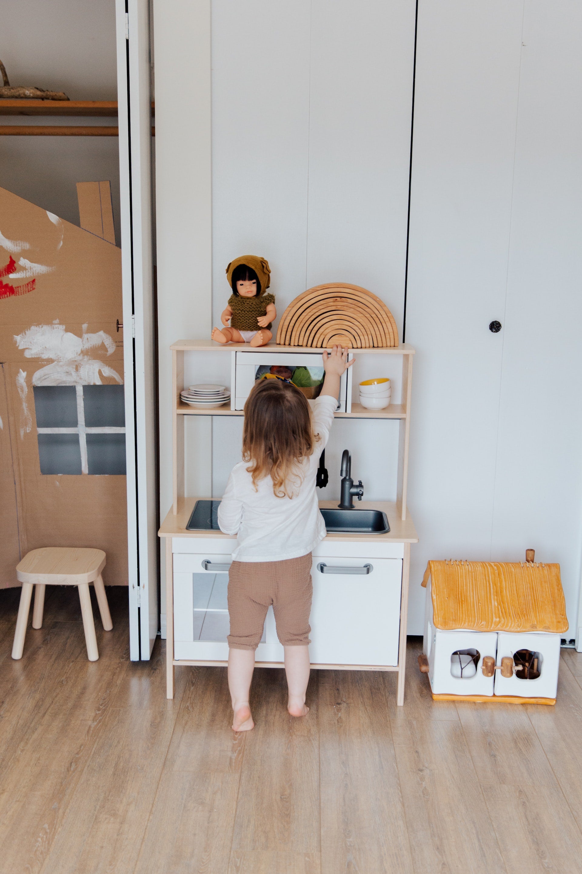a toddler using a play kitchen