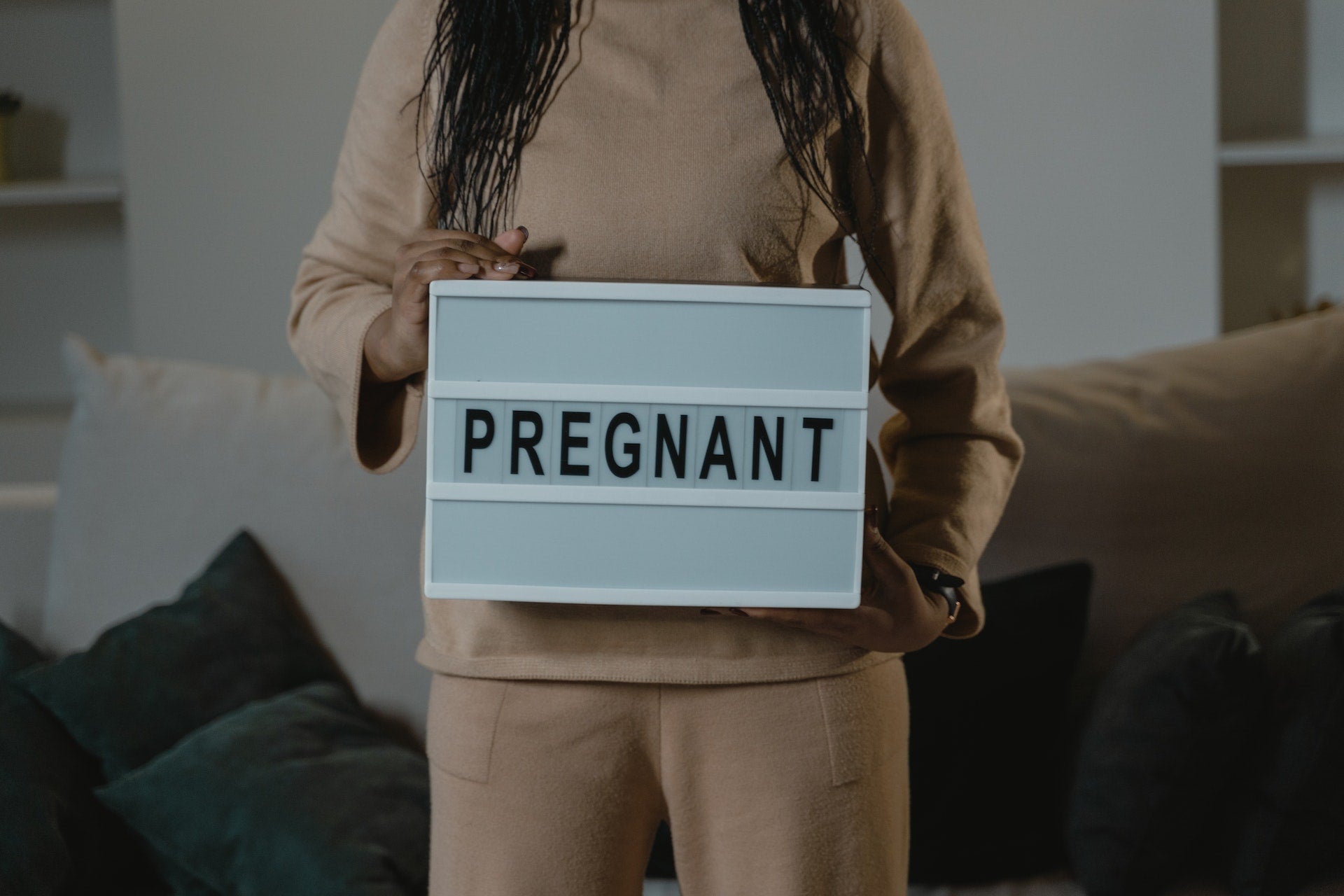 woman holding a pregnant sign