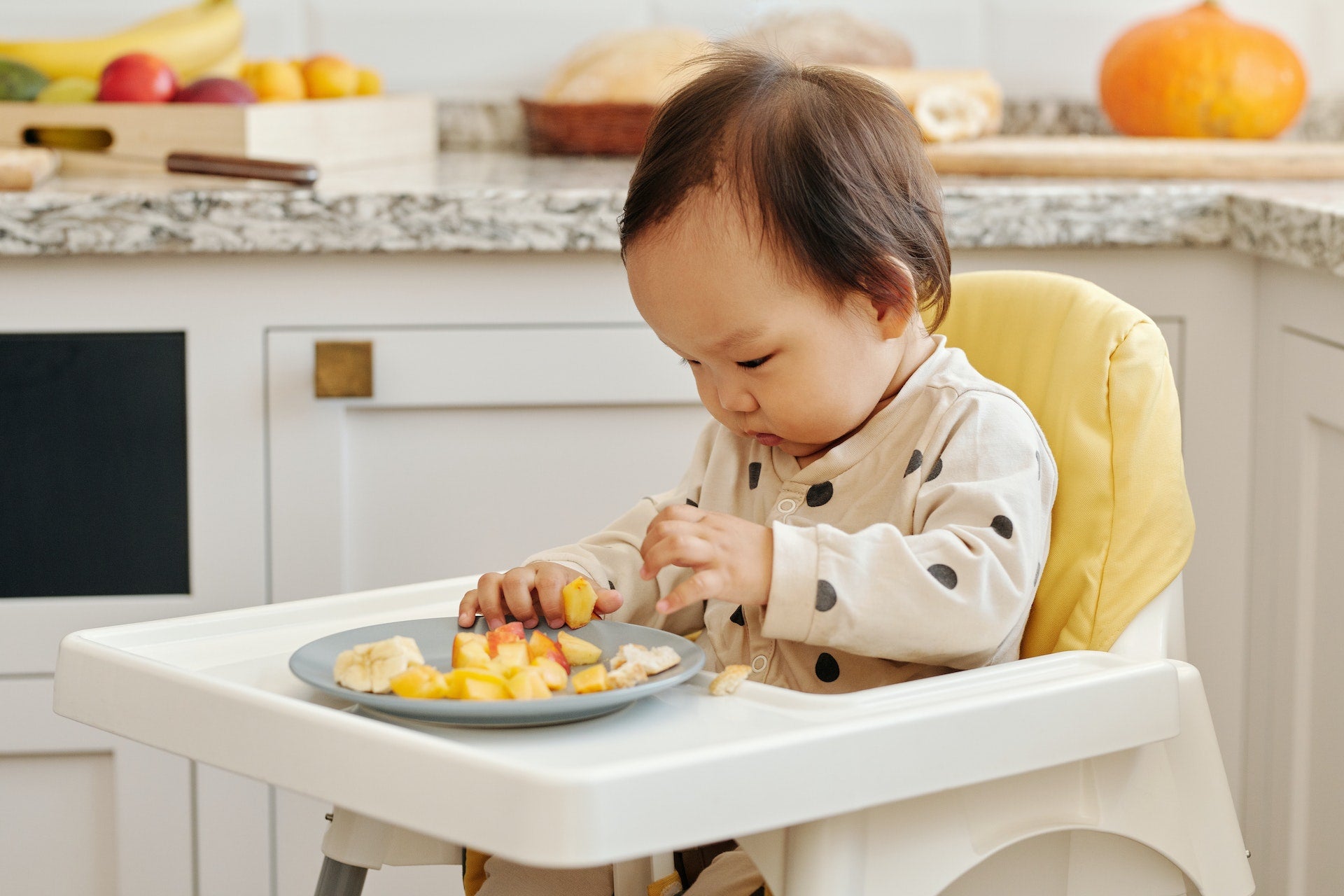 a baby in a high chair eating with their hands