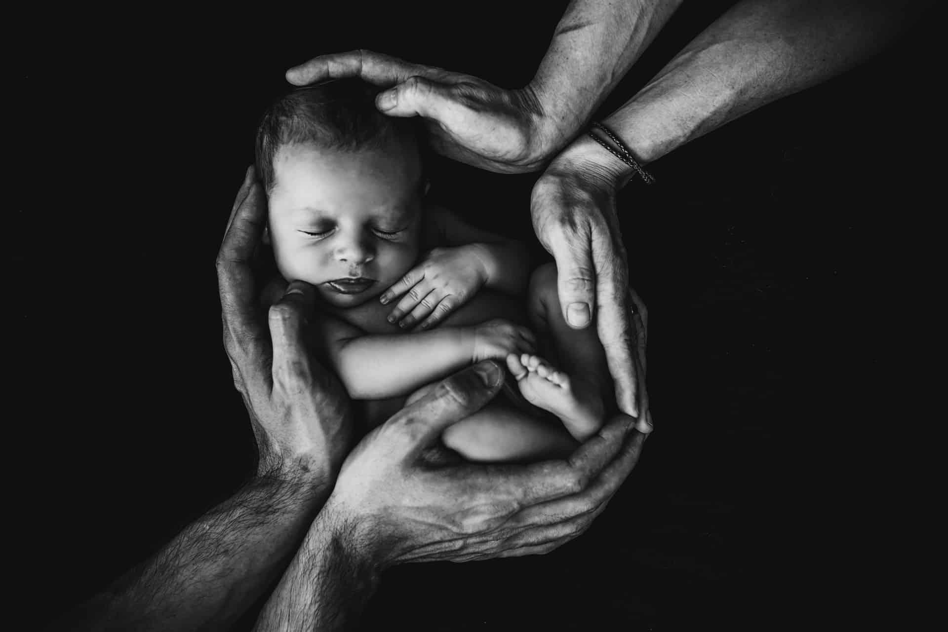 Sleeping baby held by parents