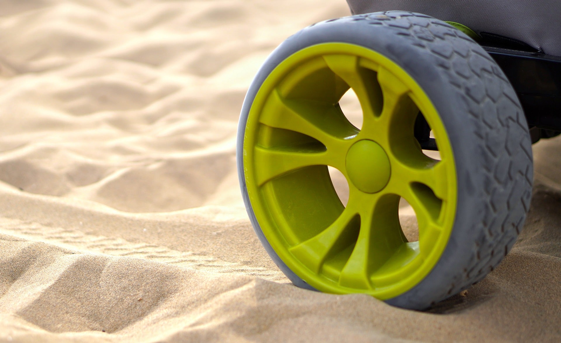 Stroller wheel in the sand at the beach