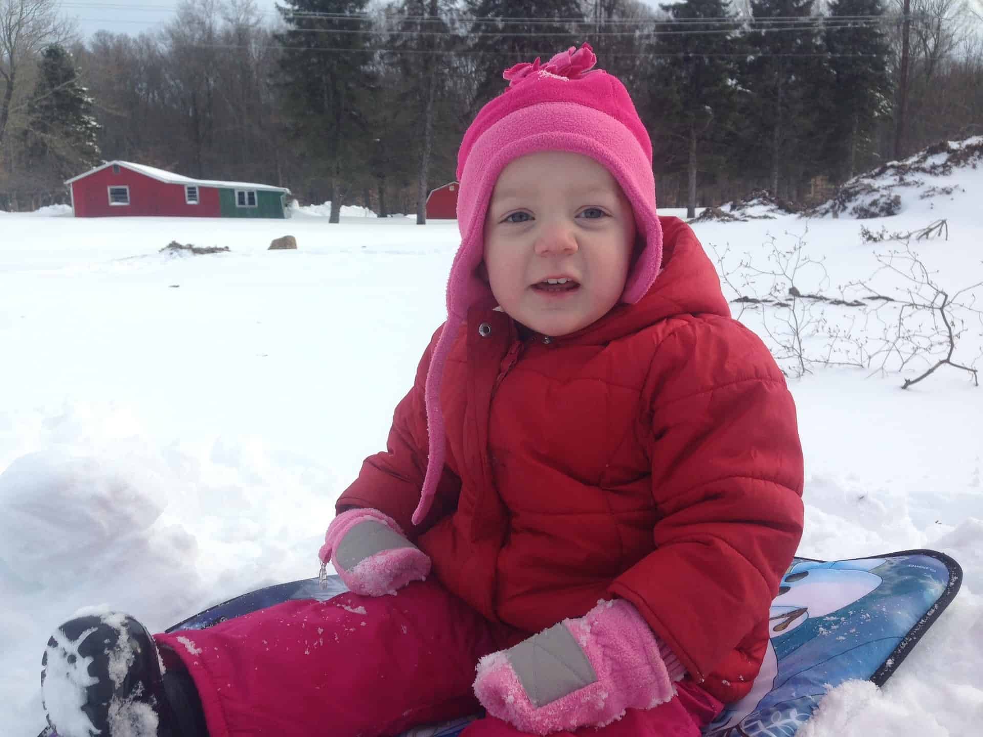 Child with a winter hat on a sled