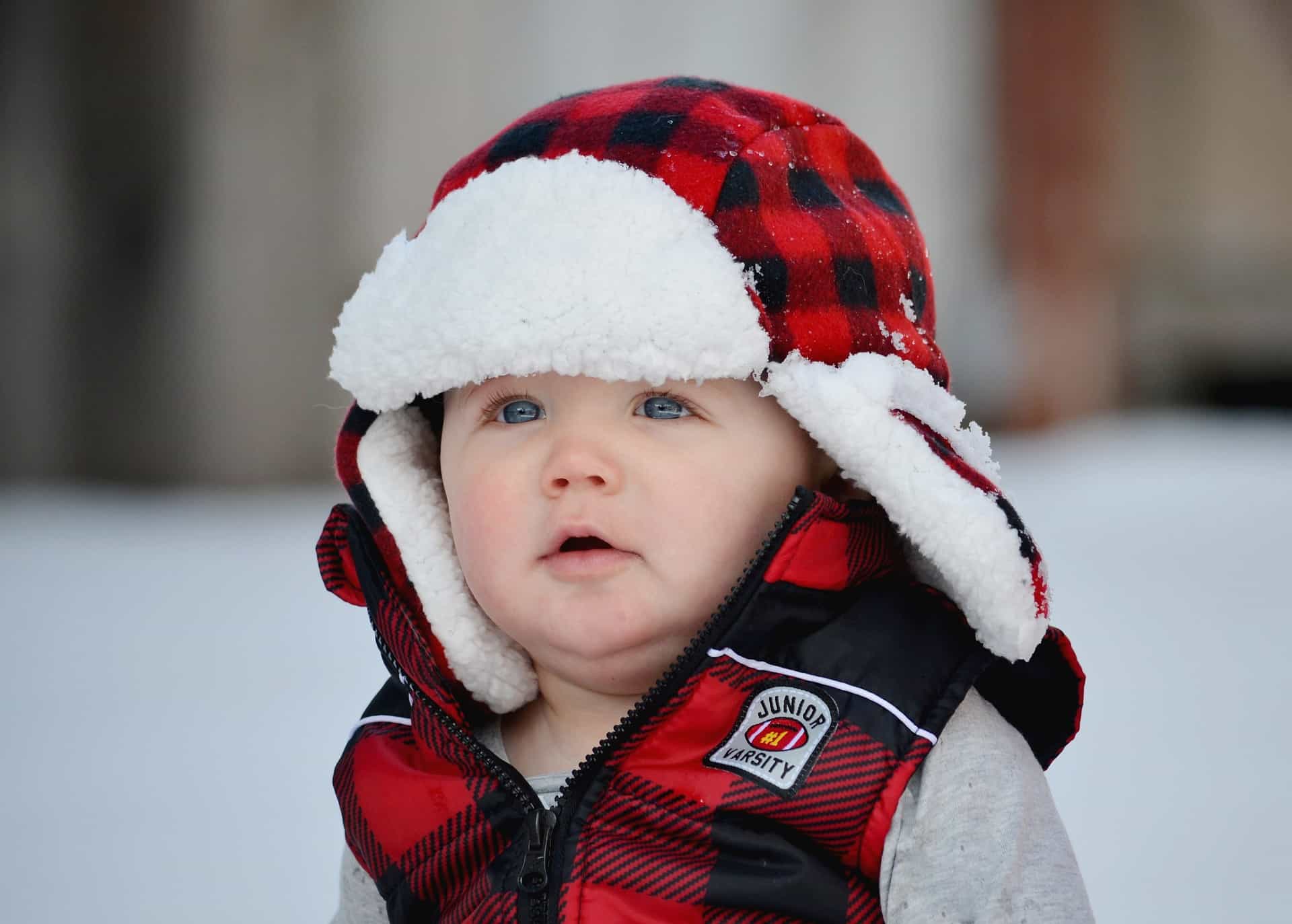 Baby with trapper hat in the snow