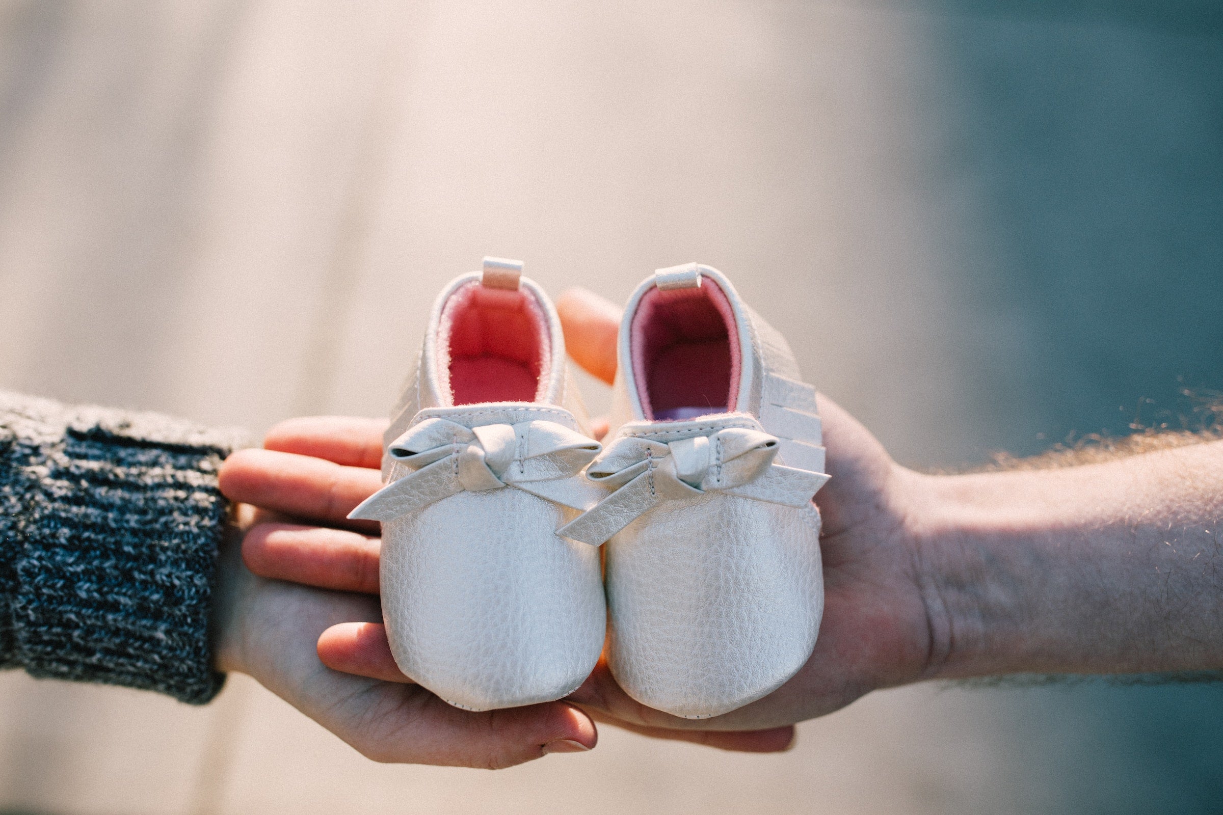 couple holding baby shoes