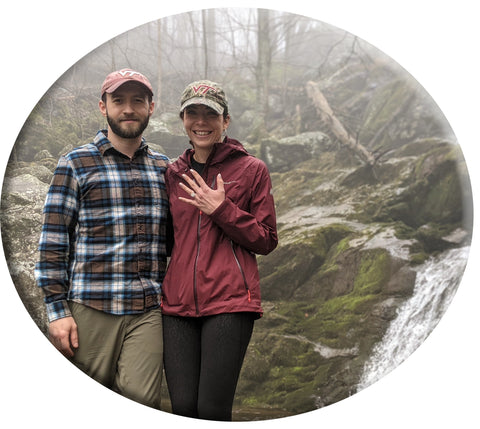 Happy couple showing off engagement ring in wilderness