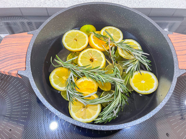 Pot on stove with water, lemon slices, and rosemary sprigs