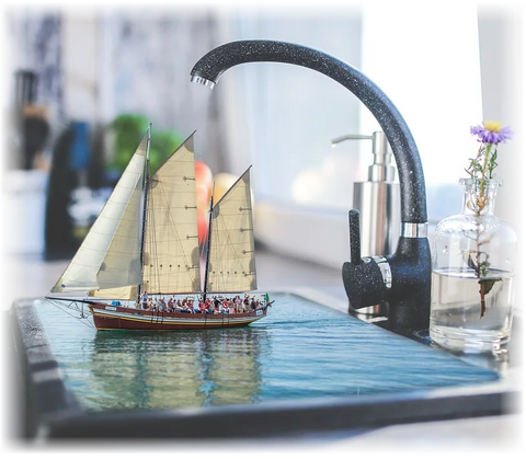 bateau flotte dans l'evier plein d'eau sous le robinet