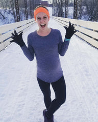 Woman standing in snow after a run