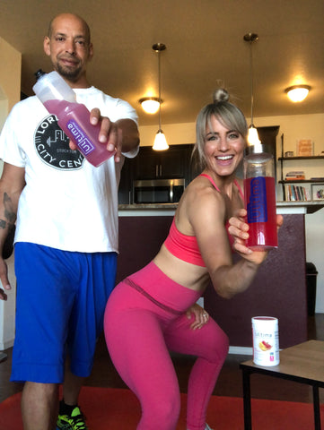 Man and woman smiling and rehydrating with Ultima Replenisher after a stretch workout