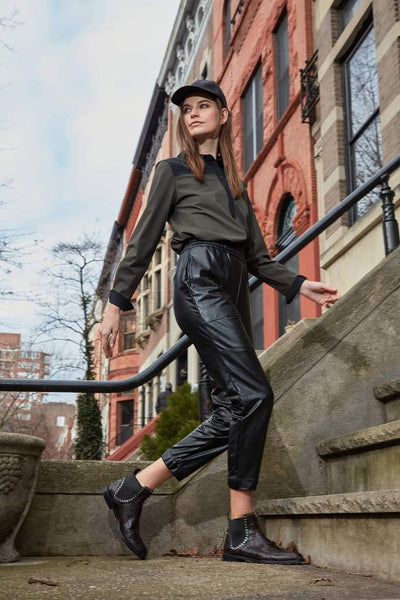 Lyssé black faux leather joggers on model walking up steps