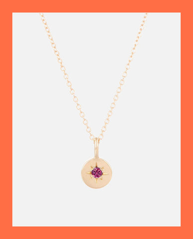 a image of an astral birthstone necklace on orange background