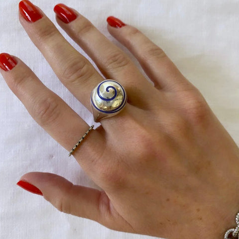 A hand with a swirl ring on it. 