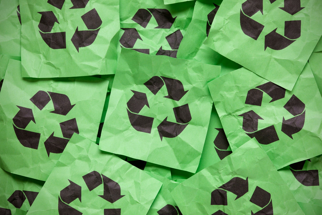 Recycling logo on pieces of green paper
