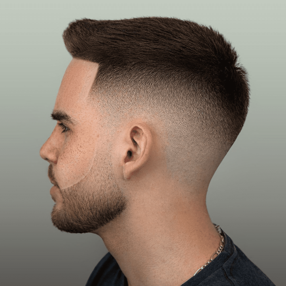 Side profile of a man with a High Skin Fade haircut, featuring short hair on top that gradually fades to the skin on the sides and back. The hairstyle creates a sharp and striking contrast, making it a trendy choice for men seeking bold fade haircuts.