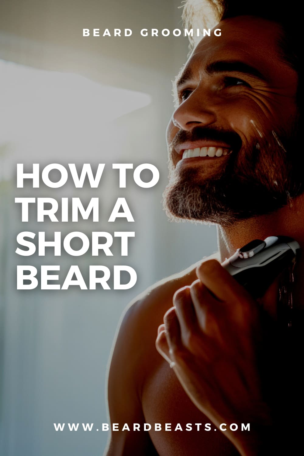 Smiling man with a short beard using an electric trimmer, with text overlay 'Beard Grooming: How To Trim A Short Beard - www.beardbeasts.com' - Perfect for sharing on Pinterest.