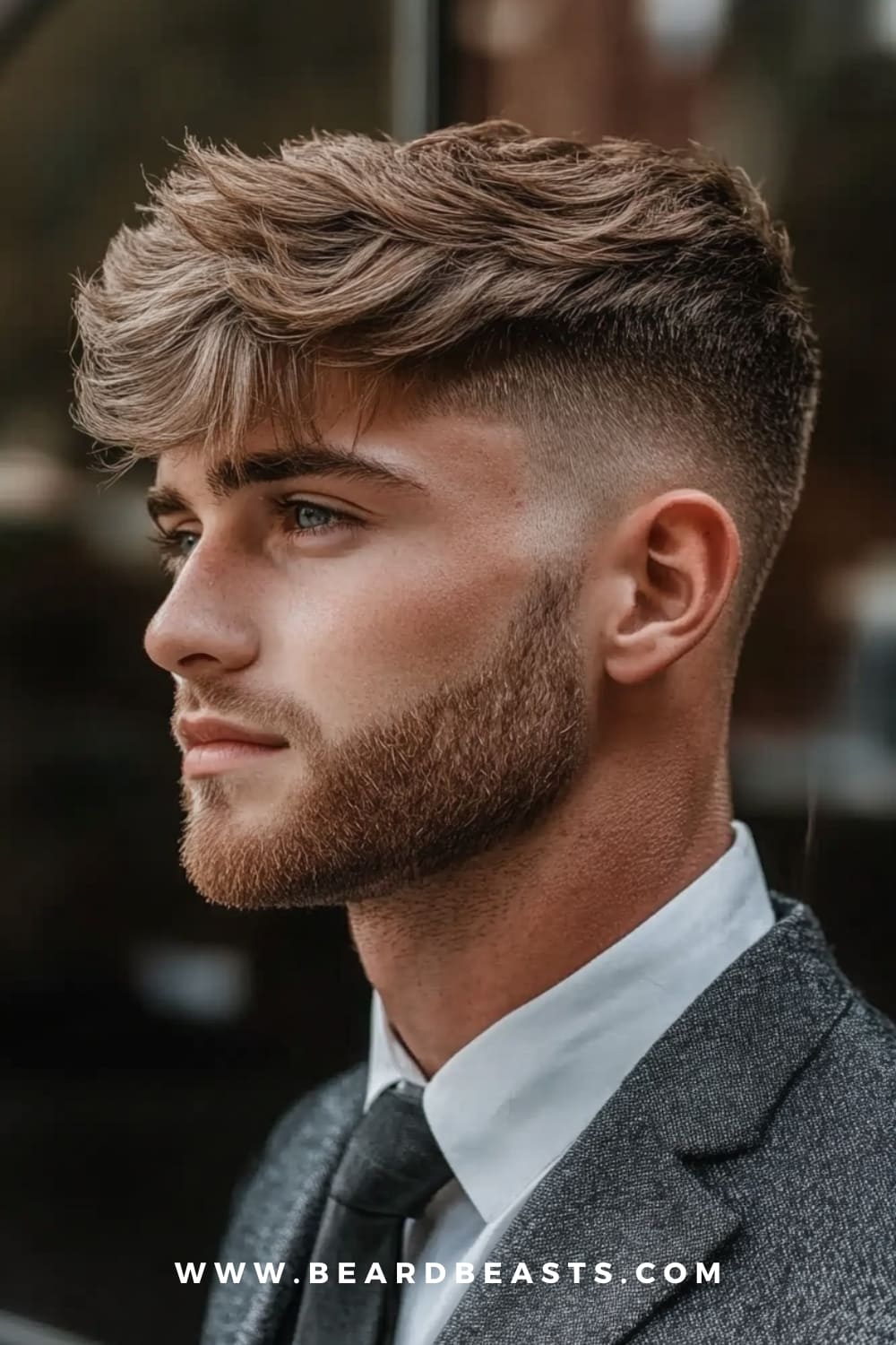 Side view of a man with a textured fringe haircut and a neatly groomed beard. This short hairstyle is ideal for men with round faces, as the textured top adds volume and height while the tapered sides create a more defined and elongated look. Perfect for balancing facial features.